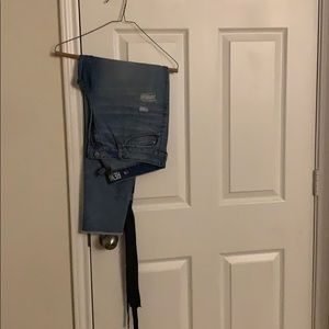 Ripped jeans with black ribbon on the side